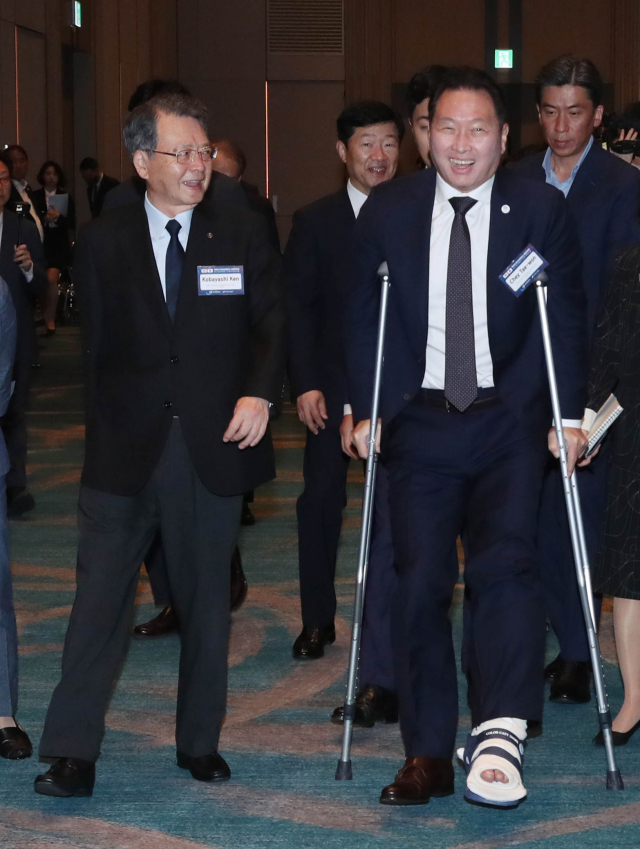 다리를 다친 최태원(오른쪽) 대한상의 회장이 목발을 짚고 고바야시 켄 일본상의 회장과 9일 부산 시그니엘 호텔에서 열린 ‘제12회 한일상공회의소회장단회의’에 참석하기 위해 이동하고 있다. 사진 제공=대한상의