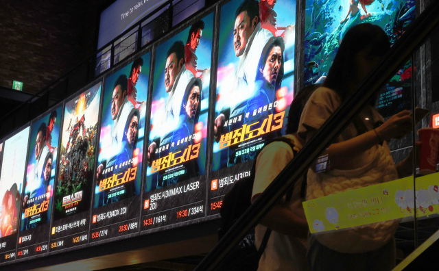 지난 6일 서울 시내 한 극장에서 관람객들이 영화 '범죄도시 3' 홍보물 앞을 지나고 있다. 연합뉴스