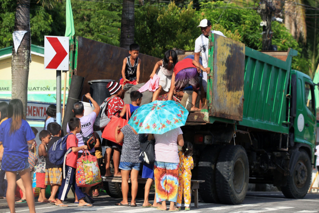 필리핀 알바이주 마욘 화산의 폭발 경보가 3단계로 상향 조정되자 9일(현지시간) 인근 마을 주민들이 짐을 들고 대피하고 있다. AFP 연합뉴스