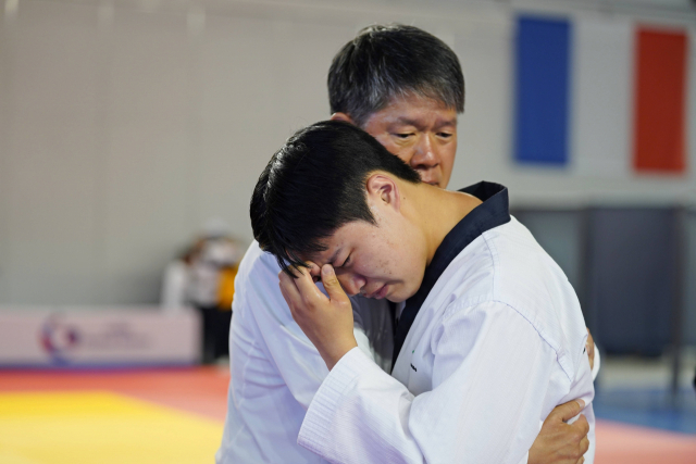 발달장애 태권도 국가대표 복준서(오른쪽)가 9일 버투스 글로벌 게임 품새 개인 결승전에서 은메달을 획득한 뒤 이용훈 스페셜올림픽코리아 회장의 품에 안겨 눈물을 흘리고 있다. 사진 제공=스페셜올림픽코리아