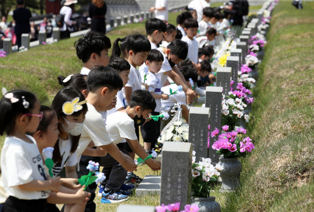 지난 5월 5·18 민주화운동 43주년을 기리기 위해 광주 북 구 운정동 국립 5·18민주묘지에서 아이들이 헌화하고 있다. 사진=연합뉴스