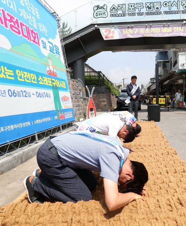 14일 인천시 남동구 소래포구 전통어시장에서 상인들이 자정대회를 열고 고객 신뢰 회복을 위한 사과를 하고 있다. 연합뉴스