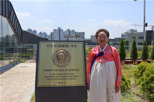 한종섭 여사가 지난 9일 서울 성북구 고려대학교 안암병원 옥외정원에 있는 '한종섭 정원' 안내판 옆에서 기념 촬영하고 있다. 사진=고려대의료원 제공