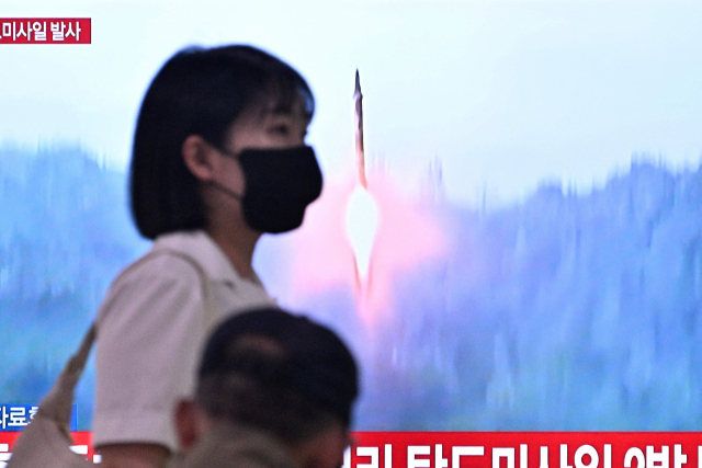 15일 서울역에 설치된 스크린 앞으로 북한 미사일 발사 소식이 전해지고 있다. AFP연합뉴스)