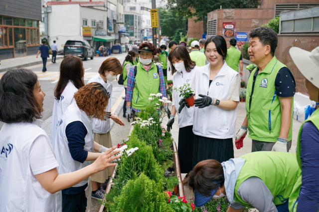 BAT로스만스 임직원과 사단법인 자연보호연맹 서울시협의회 자원봉사자들이 ‘꽃밭’캠페인 일환으로 실시된 화단 조성 후 기념사진을 촬영하고 있다. BAT로스만스 제공