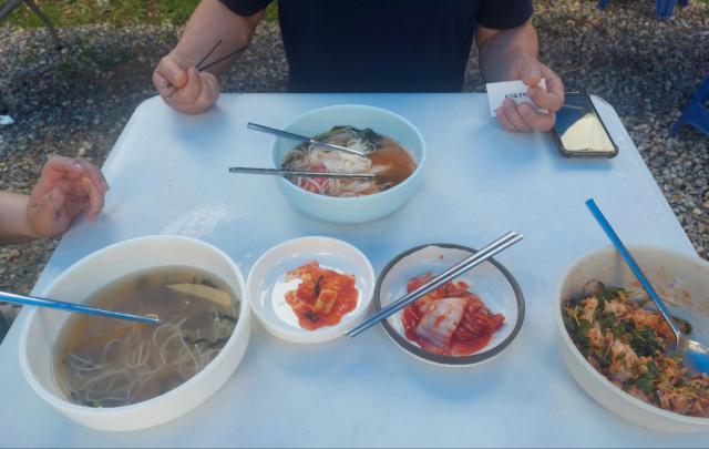 16일 오후 퇴촌 토마토 축제에서 국수와 소고기 비빔밥으로 식사중인 조민제씨 일가족. 이들은 총 2만4000원을 큰 부담 없이 지불했다. 사진 = 손대선 기자