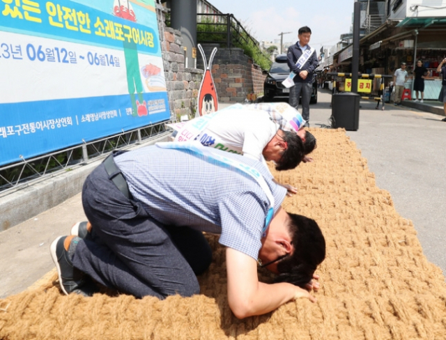 14일 인천시 남동구 소래포구 전통어시장에서 상인들이 자정대회를 열고 신뢰 회복을 약속하며 사과하고 있다. 인천=연합뉴스