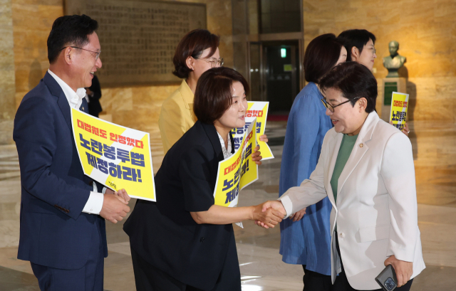 임이자 환경노동위원회 국민의힘 간사가 19일 서울 여의도 국회 로텐더홀에서 노란봉투법 처리 촉구 피케팅을 하고 있는 정의당 의원들과 인사하고 있다. 연합뉴스