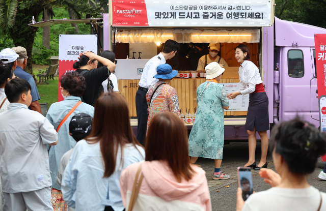 이스타항공 승무원들이 20일 오후 제주도 서귀포시 노리매 공원에서 이스타항공 연합사 제주 패키지 상품 관광객과 이스타항공을 이용해 제주를 찾은 여행객을 대상으로 음료와 기념 굿즈를 증정하는 현장 이벤트를 진행하고 있다. 서귀포시=권욱 기자 2023.6.20