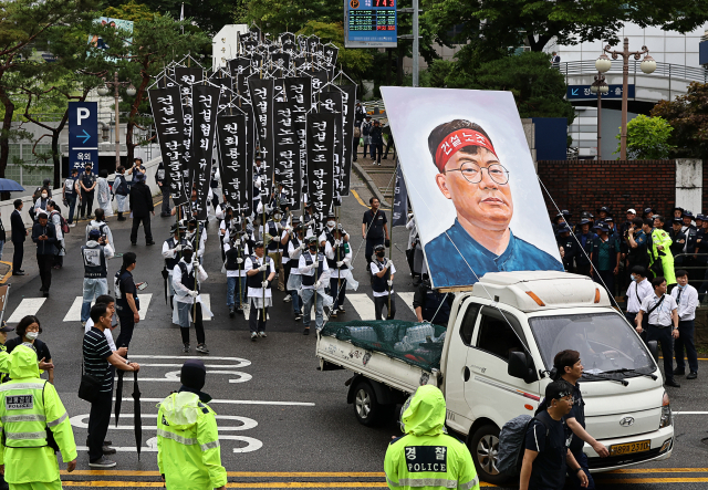 21일 오전 서울 종로구 서울대병원 장례식장에서고(故)양회동 씨의 발인미사를 마친 건설노조 조합원들이 노제를 위해 서대문구 경찰청으로 이동하고 있다. 연합뉴스