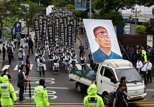 21일 오전 서울 종로구 서울대병원 장례식장에서 고(故)양회동 씨의 발인미사를 마친 건설노조 조합원들이 노제를 위해 서대문구 경찰청으로 이동하고 있다. 연합뉴스