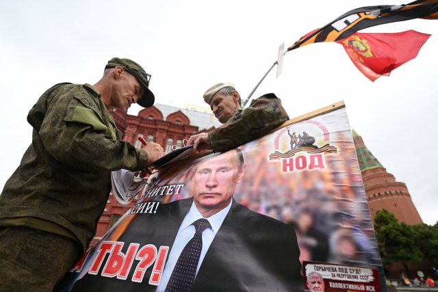 블라디미르 푸틴 러시아 대통령 지지자들이 24일(현지 시간) 모스크바 붉은 광장에서 푸틴 대통령의 초상화를 펼쳐 보이고 있다. AFP연합뉴스