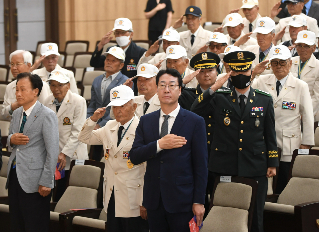 25일 화성시청 대강당에서 열린 ‘제73주년 6·25전쟁’ 기념식에서 정명근 시장(가운데 양복)을 비롯한 참전용사 등이 국민의례를 하고 있다. 사진 제공 = 화성시