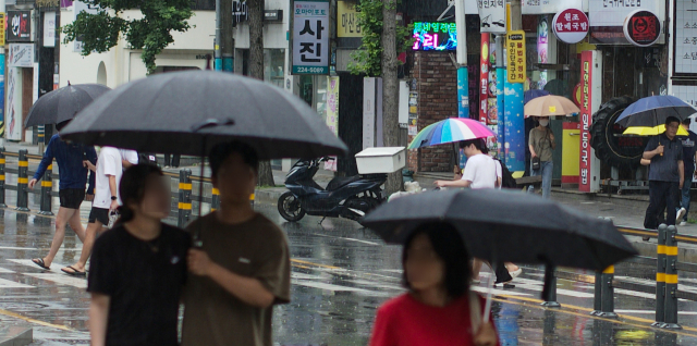 25일 오후 경남 창원시 마산합포구 한 거리에서 시민들이 우산을 쓴 채 걷고 있다. 연합뉴스