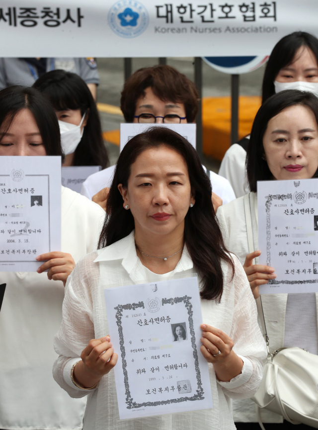 대한간호협회 소속 간호사 등이 26일 오전 세종시 정부세종청사 보건복지부 앞에서 '간호법 허위사실 유포·불법진료 묵인 보건복지부 규탄' 간호사 면허증 반납 기자회견을 하고 있다. 연합뉴스