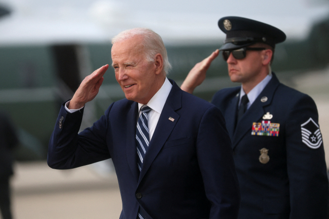 조 바이든(왼쪽) 미국 대통령이 28일(현지 시간) 미국 메릴랜드주 앤드루스 공군기지에서 백악관으로 돌아가기 위해 전용기에 탑승하기 전에 경례를 하고 있다. 로이터연합뉴스