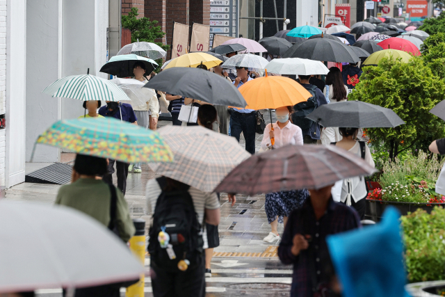 서울시 전역에 호우주의보가 내려진 29일 오후 서울 강남역 인근에서 우산을 쓴 시민들이 이동하고 있다. 연합뉴스