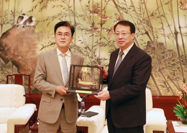 김태흠(왼쪽) 충남도지사가 중국 상하이시 궁정(오른쪽) 시장에게 거북선 모형 선물을 전달하고 있다. 사진제공=충남도