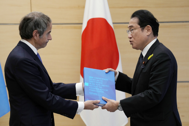 라파엘 그로시(왼쪽) 국제원자력기구(IAEA) 사무총장이 4일 도쿄 총리 관저에서 기시다 후미오 총리에게 후쿠시마 원전 오염수 방류 계획에 관한 IAEA의 최종 보고서를 전달하고 있다. 도쿄=AP연합뉴스