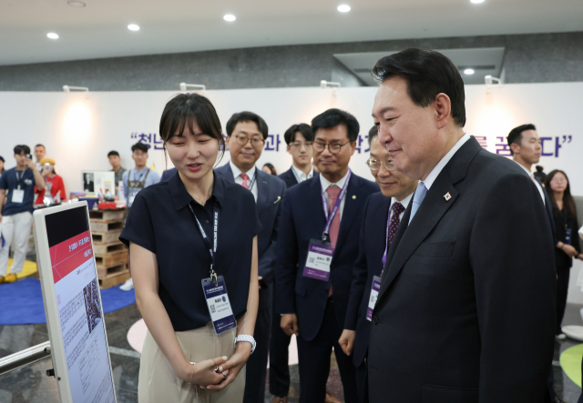 윤석열 대통령이 5일 서울 강남구 역삼동 한국과학기술회관에서 열린 ‘제1회 세계한인과학기술인대회’ 개회식에 참석한 뒤 미래 한인 과학인 곽세이(프랑스) 씨의 연구 관련 설명을 듣고 있다. 연합뉴스