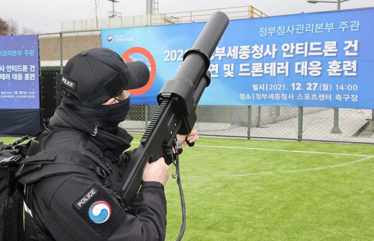 2021년 12월 27일 세종시 어진동 정부세종청사 축구장에서 열린 안티드론건 성능 시연 및 드론 테러 대응 훈련에서 재밍건을 든 정부 청사 관계자가 드론을 강제로 착륙시키고 있다.사진 제공=행정안전부