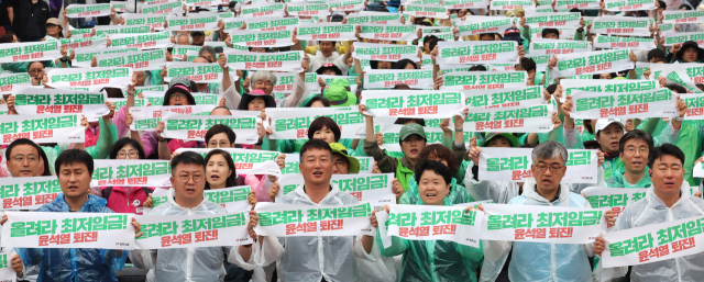 전국민주노동조합총연맹 관계자들이 지난달 29일 오후 세종시 정부세종청사 고용노동부 앞에서 '모두를 위한 최저임금 대폭인상, 비정규직 철폐'를 촉구하는 결의대회를 열고 구호를 외치고 있다. 연합뉴스