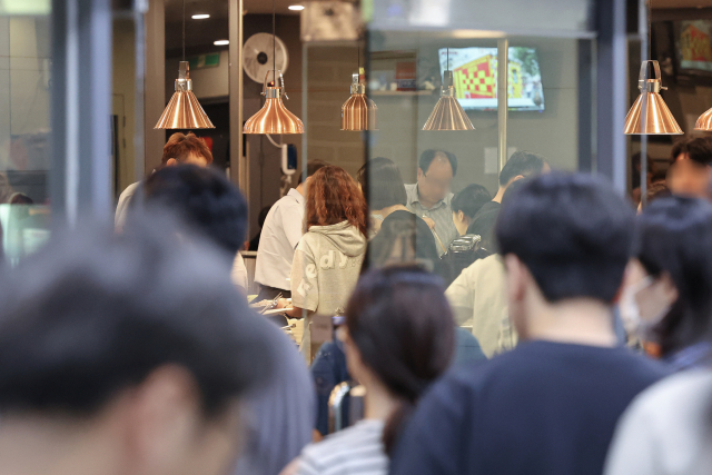 서울 시내 한 빌딩 식당 앞에서 직장인들이 점심을 먹기 위해 줄을 서 있다. 연합뉴스