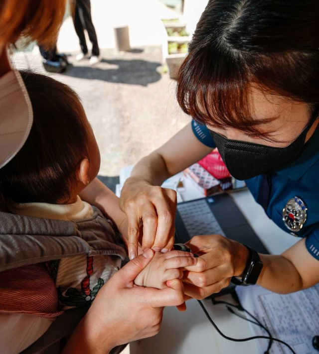 서울 종로구 서울경찰청어린이집에서 종로경찰서 소속 경찰이 어린이들의 사전 지문을 등록해주고 있다. 연합뉴스