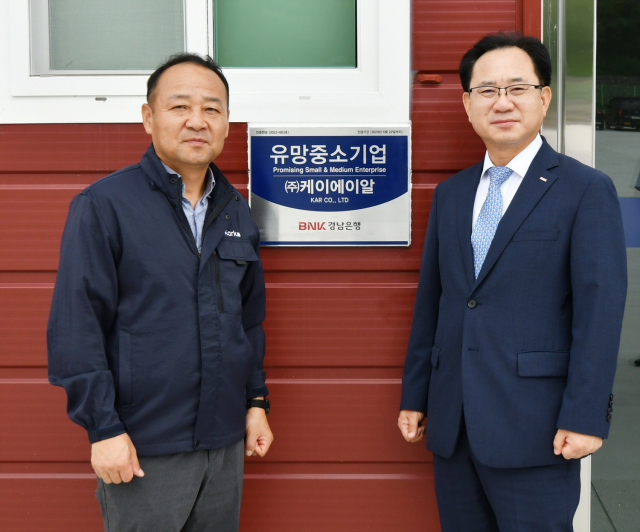 이상봉 BNK경남은행 부행장(오른쪽)과 최성재 케이에이알 대표가 유망중소기업 현판식을 갖고 있다. 사진제공=BNK경남은행