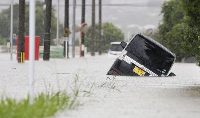 일본 후쿠오카현 구루메시의 도로에서 한 차량이 물에 잠겨 움직이지 못하고 있다. 로이터 연합뉴스