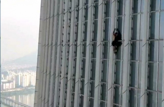 영국인 남성이 지난달 12일 오전 서울 송파구 롯데월드타워를 무단으로 등반하고 있다. 사진제공=송파소방서