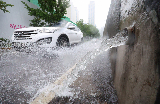 전국적으로 장맛비가 내린 11일 오후 서울 중구 서소문고가차도 배수로를 따라 흘러내린 물이 인근 도로로 흘러내리고 있다. 연합뉴스