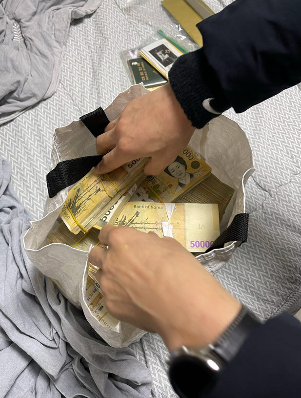 경찰이 피의자들이 쇼핑백에 보관해놓은 현금을 확인하고 있다. 사진=서울경찰청 강력범죄수사대 제공