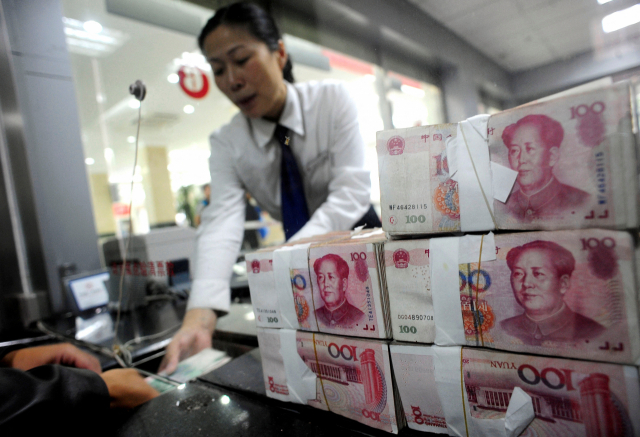 중국 안후이성 허페이의 공상은행 점포에서 은행원이 고객에게 위안화 지폐를 건네고 있다. 로이터연합뉴스