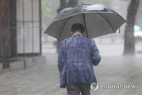 (서울=연합뉴스) 신현우 기자 = 전국 대부분 지역에 장맛비가 내린 13일 오후 서울 여의도 국제금융로에서 우산을 쓴 시민이 이동하고 있다. 2023.7.13 nowwego@yna.co.kr