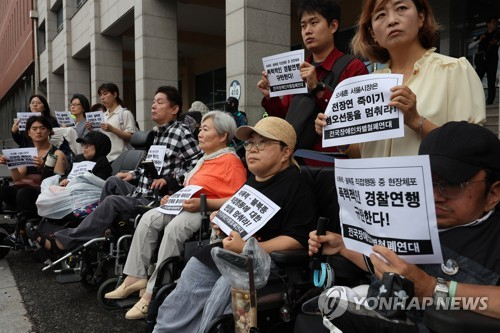 15일 오후 서울 남대문경찰서 앞에서 전장연 관계자들이 전날 박경석 전장연 대표가 경찰에 체포된 것과 관련해 규탄 기자회견을 하고 있다. 연합뉴스