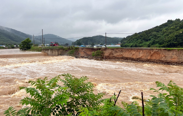 15일 새벽 충청권에 쏟아진 폭우로 충남 청양군 정산면 학암리 하천 둑이 무너져 있다. 연합뉴스