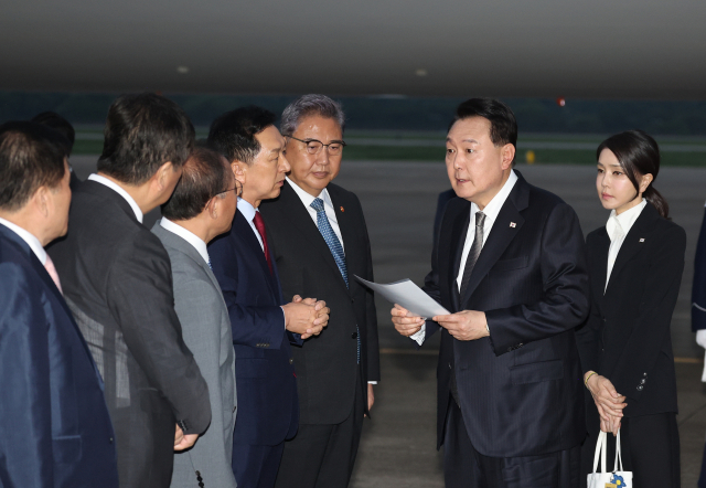 리투아니아에서 열린 북대서양조약기구(NATO·나토) 정상회의와 폴란드·우크라이나 방문을 마친 윤석열 대통령이 17일 성남 서울공항을 통해 귀국해 국민의힘 김기현 대표가 준비한 자료를 보며 박진 외교부 장관 등과 대화하고 있다./연합뉴스