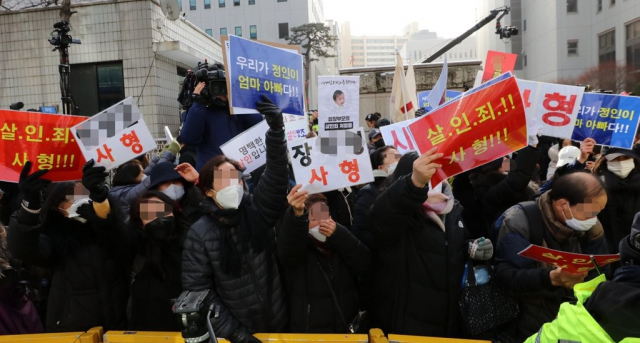 2021년 1월 정인양을 학대해 숨지게 한 혐의를 받는 양부모의 첫 재판이 열린 13일 서울남부지법에서 양모가 탄 호송차가 법원을 빠져나가자 시민들이 항의하고 있다. 연합뉴스
