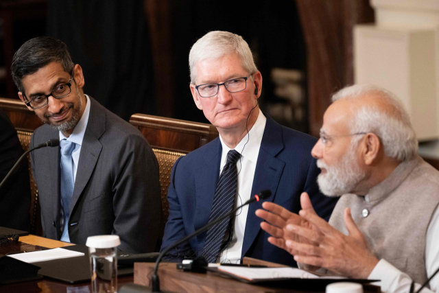 팀 국(가운데) 애플 최고경영자(CEO)가 지난달 23일(현지 시간) 백악관에서 열린 회담에서 나렌드라 모디(오른쪽) 인도 총리의 발언을 듣고 있다. AFP연합뉴스