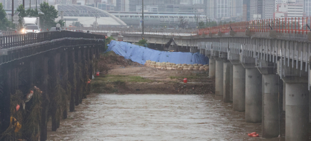 18일 오후 충북 청주시 미호천교 아래에 임시제방이 쌓여있다. 지난 15일 폭우로 미호강 제방이 무너지며 강물이 궁평2지하차도를 덮쳐 24명의 사상자가 발생했다. 연합뉴스
