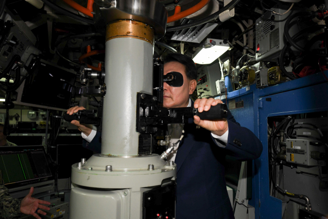 윤석열 대통령이 지난 19일 부산 해군작전사령부 부산작전기지에 입항한 미국의 오하이오급 핵추진 탄도유도탄 잠수함(SSBN) 켄터키함(SSBN-737) 내부를 시찰하며 잠망경을 살펴보고 있다. 사진 제공=미 해군