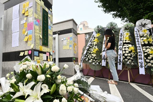 20일 초등학교 담임 교사가 극단적 선택을 하는 사건이 벌어진 서울 서초구 의 한 초등학교 정문 앞에서 한 추모객이 고인을 추모하고 있다. 성형주 기자