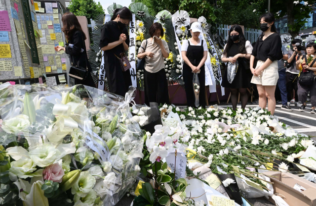 20일 한 여교사가 극단적 선택을 한 사건이 발생한 서울 서초구의 한 초교 정문 앞에 동료 교사들과 시민들이 고인을 추모하기 위해 꽃을 놓고 있다. 권욱 기자