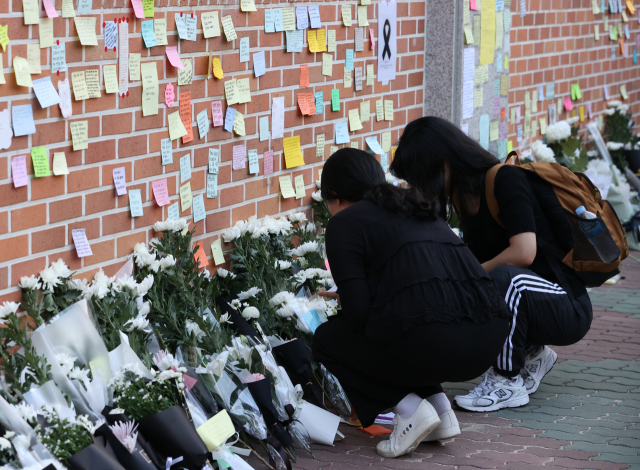 지난 20일 오후 서울 서초구 서이초등학교에 마련된 임시 추모공간에서 추모객들이 고인이 된 교사 A씨를 추모하고 있다. 연합뉴스