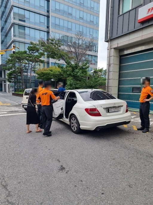 지난 16일 서울 영등포구 한 소방서 앞에 불법주차된 차량과 그 차 뒷자석에 차주의 짐을 넣어주고 있는 소방대원. 사진=온라인 커뮤니티 갈무리