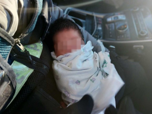20일 오후 갓난아이를 발견한 경찰관이 순찰차에서 아이를 안고 있다. 사진=강원도소방본부 제공