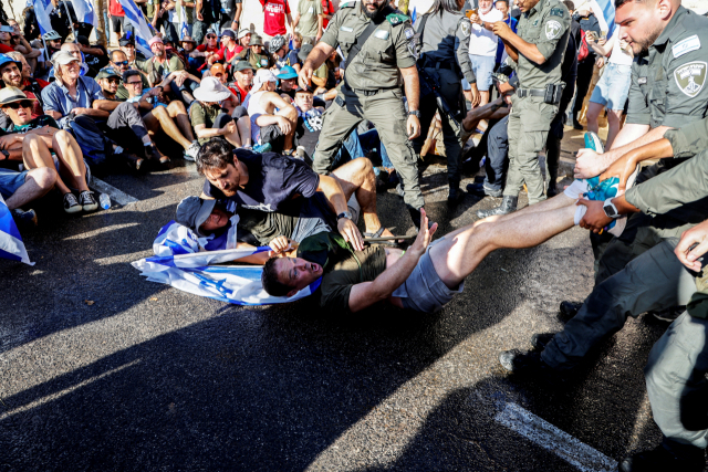 이스라엘 국경 경찰이 24일(현지 시간) 예루살렘 의회 인근 도로에서 ‘사법 정비’ 입법 반대 시위 참가자를 끌어내고 있다. 로이터연합뉴스