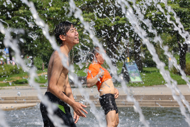 전국 곳곳 폭염주의보가 발효된 19일 오후 서울 여의도물빛광장을 찾은 학생들이 물놀이를 즐기고 있다. 연합뉴스