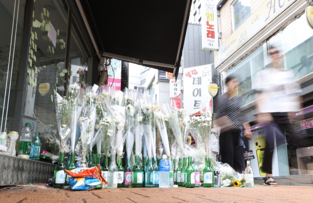 지난 25일 오후 서울 관악구 신림역 인근 상가 골목에 흉기난동 사건으로 숨진 20대 남성 피해자 A씨를 위한 추모 공간이 마련돼 있다. 연합뉴스